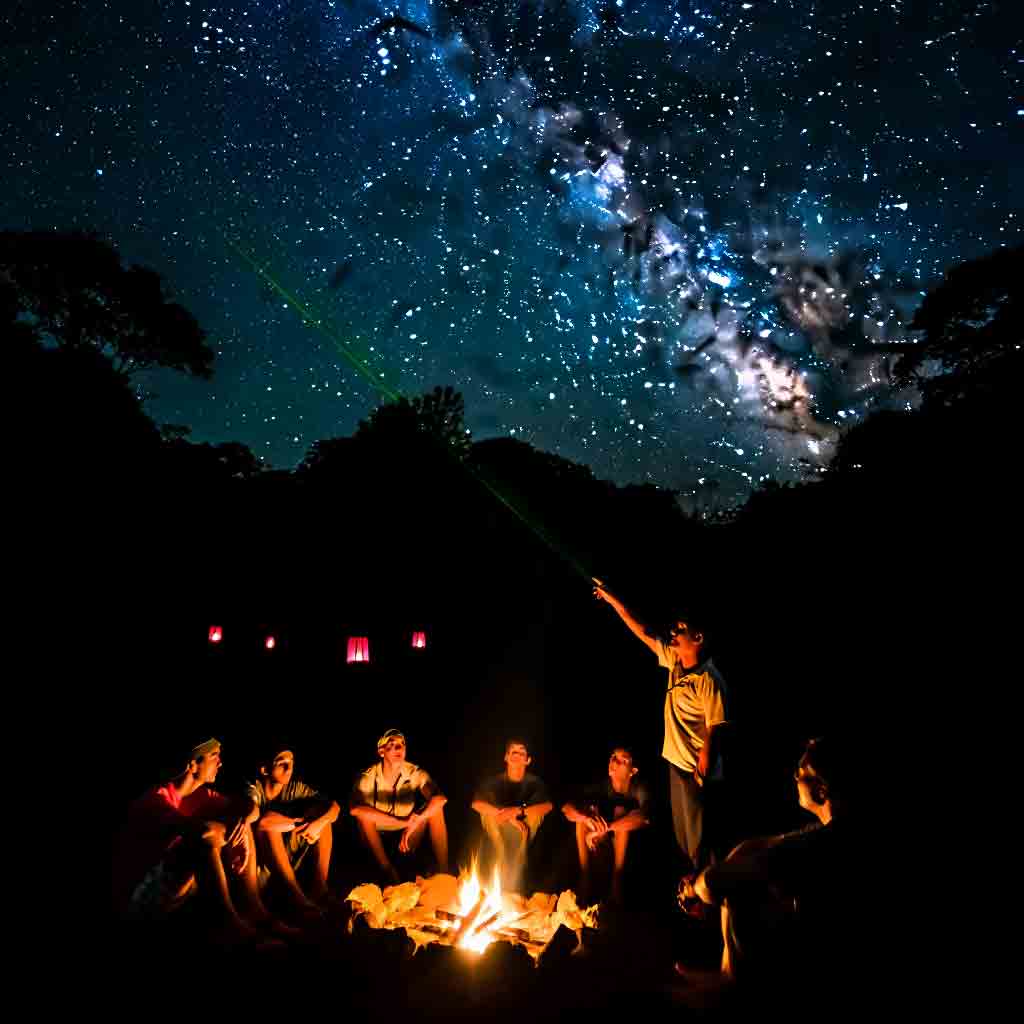 Grupo en un claro de la selva de Iguazú, observando la Vía Láctea alrededor de una fogata durante una travesía de astroturismo con Diversidad.