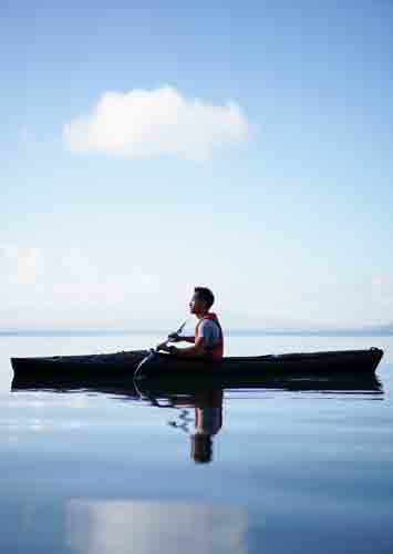 Kayakista en un momento de quietud y meditación personal sobre las aguas calmadas del Río Iguazú.